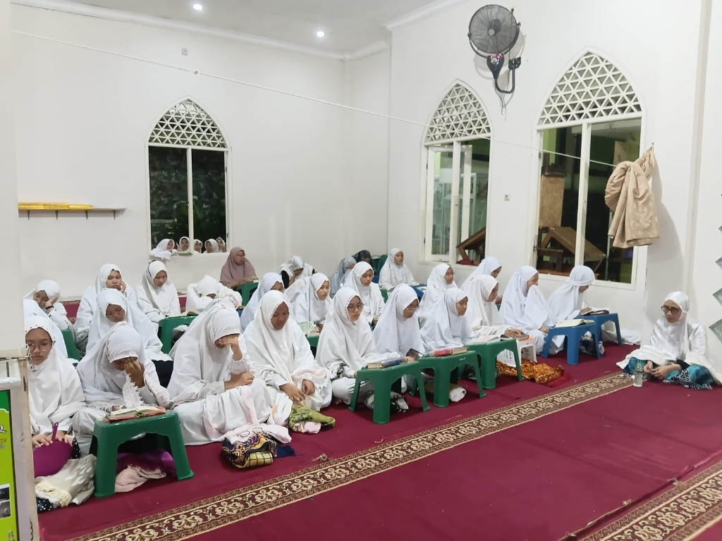 Santriwati putri berbalut mukena putih rapi khusyuk mengikuti majelis tahlil dan doa di Masjid Nurul Ilmi Bojonggede Bogor